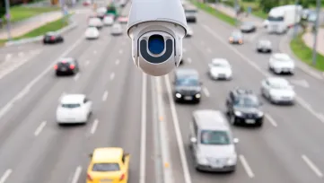 Biela dopravná monitorovacia kamera nad viacprúdovou cestou s premávkou