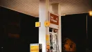 osvetlený výdajný stojan čerpacej stanice v noci, tankovacie pištole a cenový panel