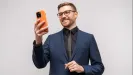 muž v obleku s mobilom v ruke, čisté biele pozadie