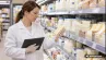 Inšpektorka kontroluje balené potraviny v regáli supermarketu